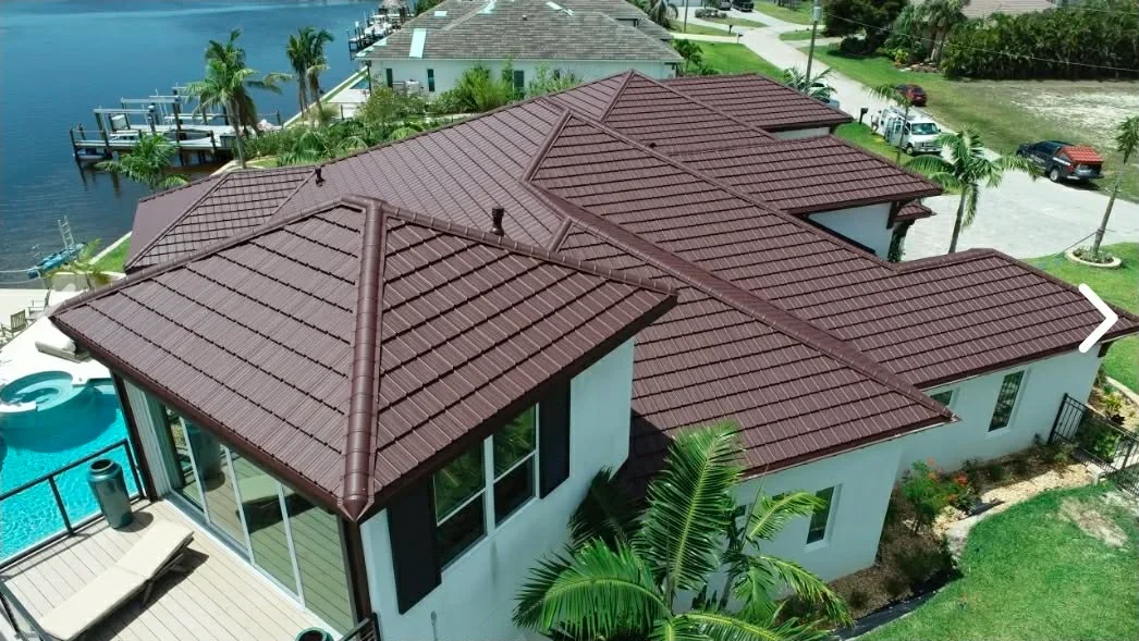 Brown concrete tile roof with hip ridges and matching trim on a white stucco home